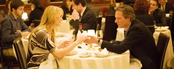 Deux personnes assises de part et d'autre d'une table à manger se tenant la main