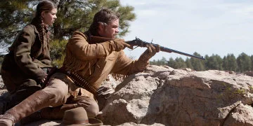 Mattie Ross s'est assise derrière LaBoeuf qui dirige son chewing-gum vers un mur de rochers