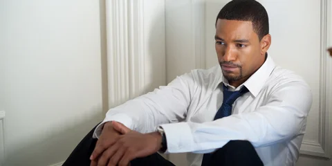 Jason Taylor Played By Laz Alonso Sitting Against A Door