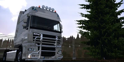A DAV truck driving on a road near some woodlands