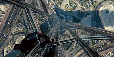 Tom Cruise escaladant un bâtiment en verre